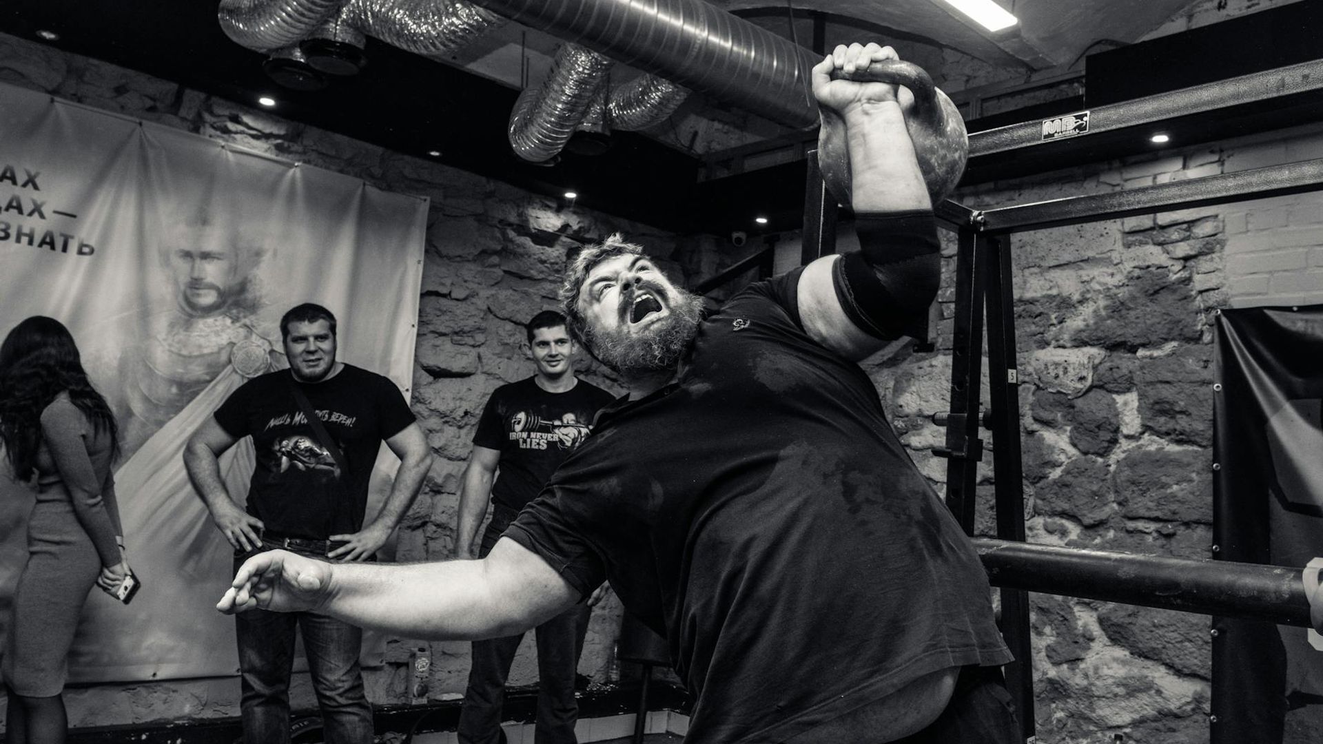 Athletic man performing strength exercises in a minimalist industrial gym.