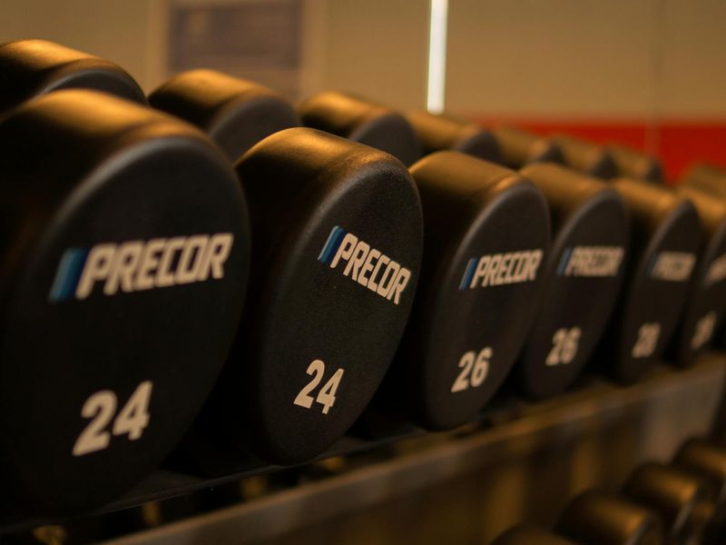 Close-up of heavy iron weights on a gym floor rack.