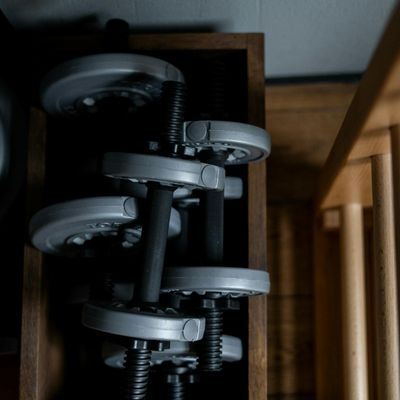 Set of chrome dumbbells arranged neatly on a metal rack.
